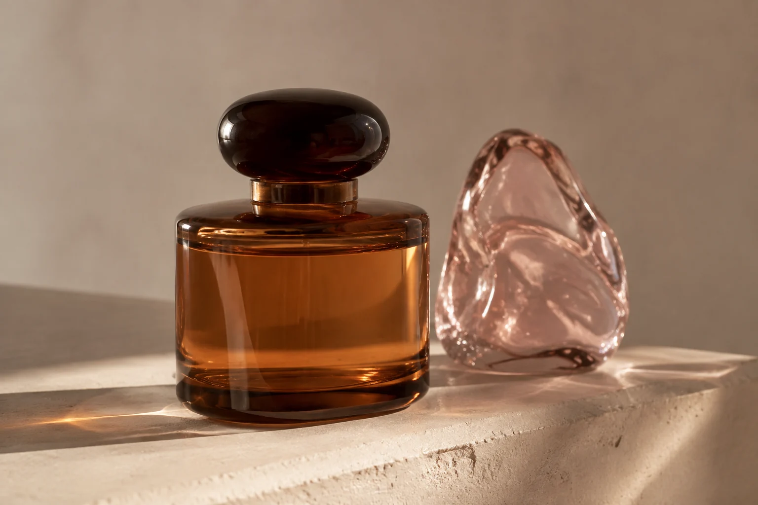 AI editorial concept: an unbranded amber-glass fragrance bottle and translucent pink glass on a cream plinth.
