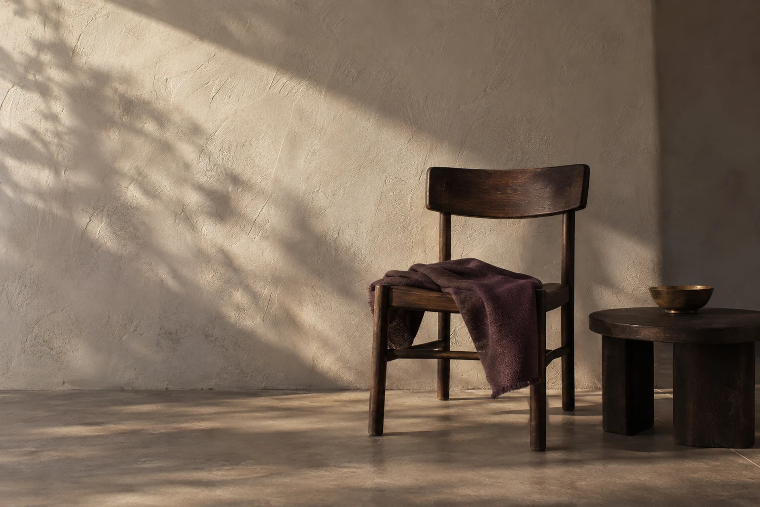 AI editorial concept: a dark wooden chair draped with plum cloth and a low table with a brass-colored bowl beside a cream plaster wall crossed by soft afternoon shadows.